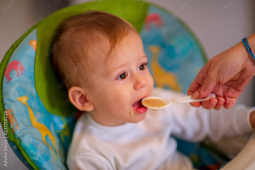 mother spoon feeding her little son. mother spoon feeding her little son.
