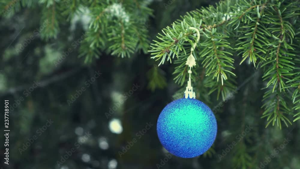 Blue Christmas bauble hanging on snowy fir tree 4K Blue Christmas bauble hanging on snowy fir tree 4K