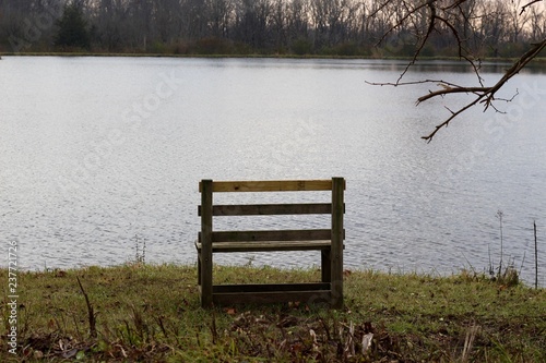 A old wood bench on the shore of the lake. © Al