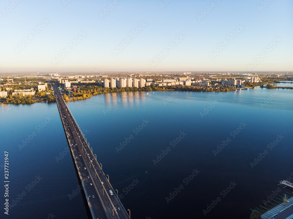 Aerial panoramic view of big river and transportation bridge over it with cars in European city
