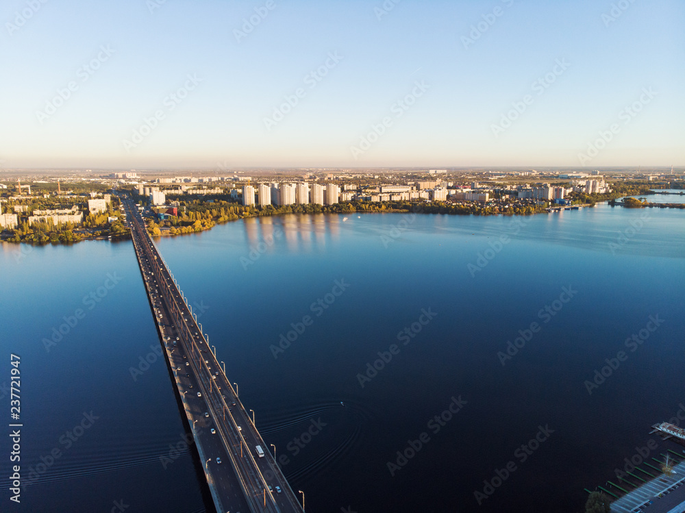 Aerial panoramic view of big river and transportation bridge over it with cars in European city Aerial panoramic view of big river and transportation bridge over it with cars in European city