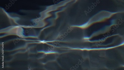 Slow motion of liquid web pattern of refracted and reflected sun shine in deep pure water close up. Vibrant abstract natural background with amazing texture of light. High speed camera shooting.
