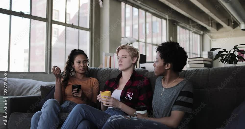 Young adult friends socialising in a loft apartment Young adult friends socialising in a loft apartment