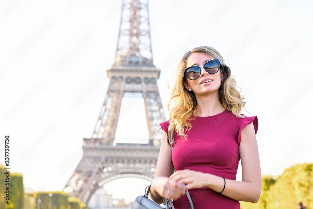 Woman at Eiffel Tower Paris, France. Young tourist girl in a red romantic dress admiring the views. Portrait soft bokeh backgrounds