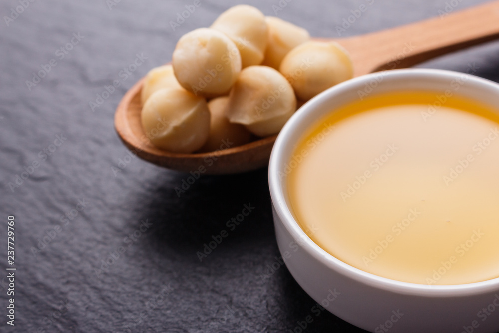 delicious macadamia nuts on a dark stone background delicious macadamia nuts on a dark stone background