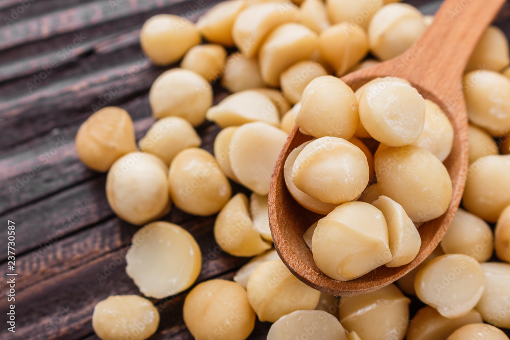 delicious macadamia nuts on a wooden rustic background delicious macadamia nuts on a wooden rustic background