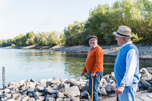 Two old friends strolling at a lake, sharing memories photo