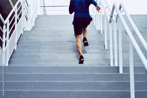 Fitness, health, and sport concept. Athletic man running upstairs