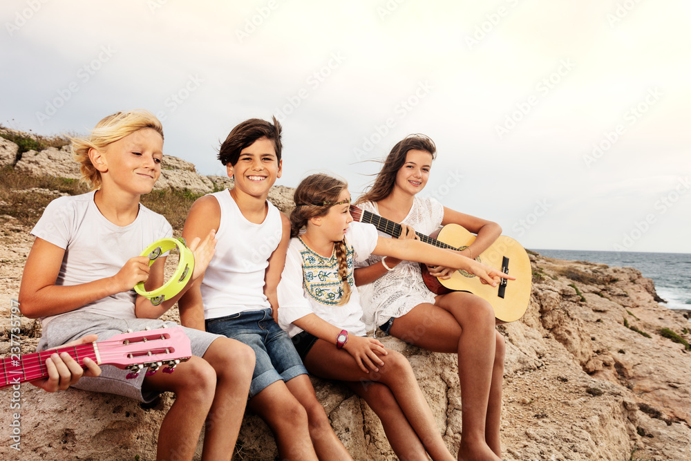 Group of young musicians having fun on the beach Group of young musicians having fun on the beach
