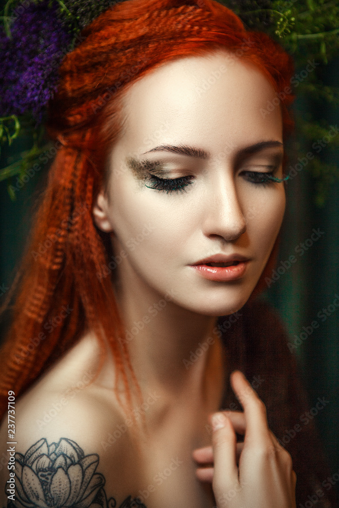 Fototapeta premium Young red head model is posing with a creative makeup 