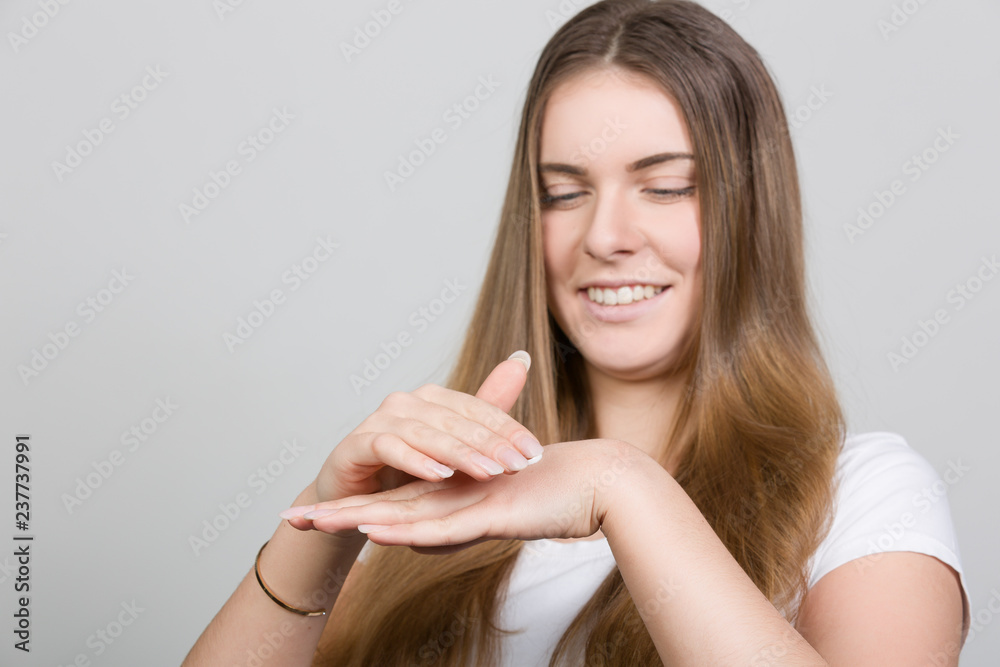 Teenager trägt Hautcreme auf ihre Hand auf Teenager trägt Hautcreme auf ihre Hand auf