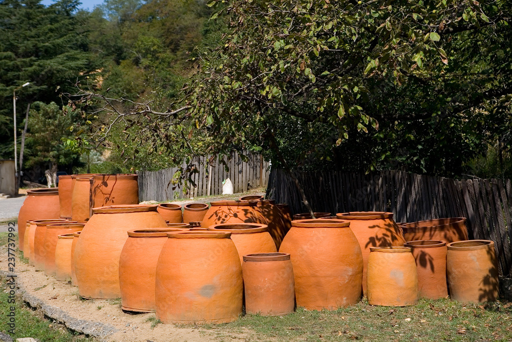 Many large earthenware jugs for wine are sold near the road. Many large earthenware jugs for wine are sold near the road.