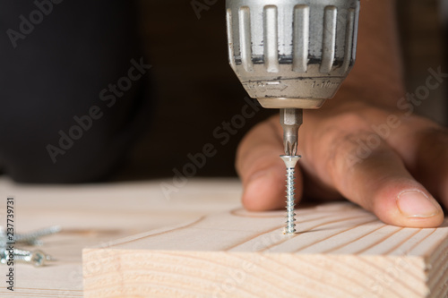 Fotografie Craftsman working with an electric screwdriver, close up
