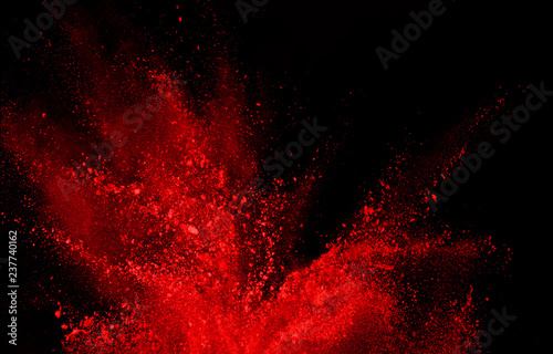 abstract red powder explosion on black background.abstract red powder splatted on black background. Freeze motion of red powder exploding.