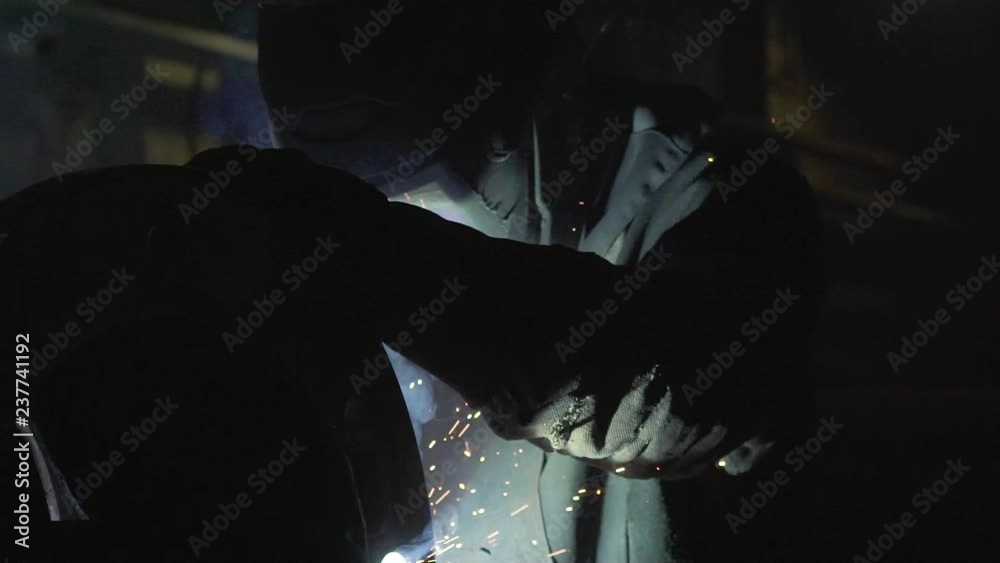 Welder working in dark workshop place slow motion shot Welder working in dark workshop place slow motion shot