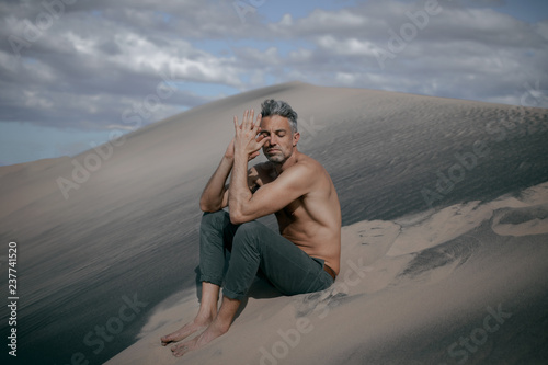 Man sitting on sand dunes