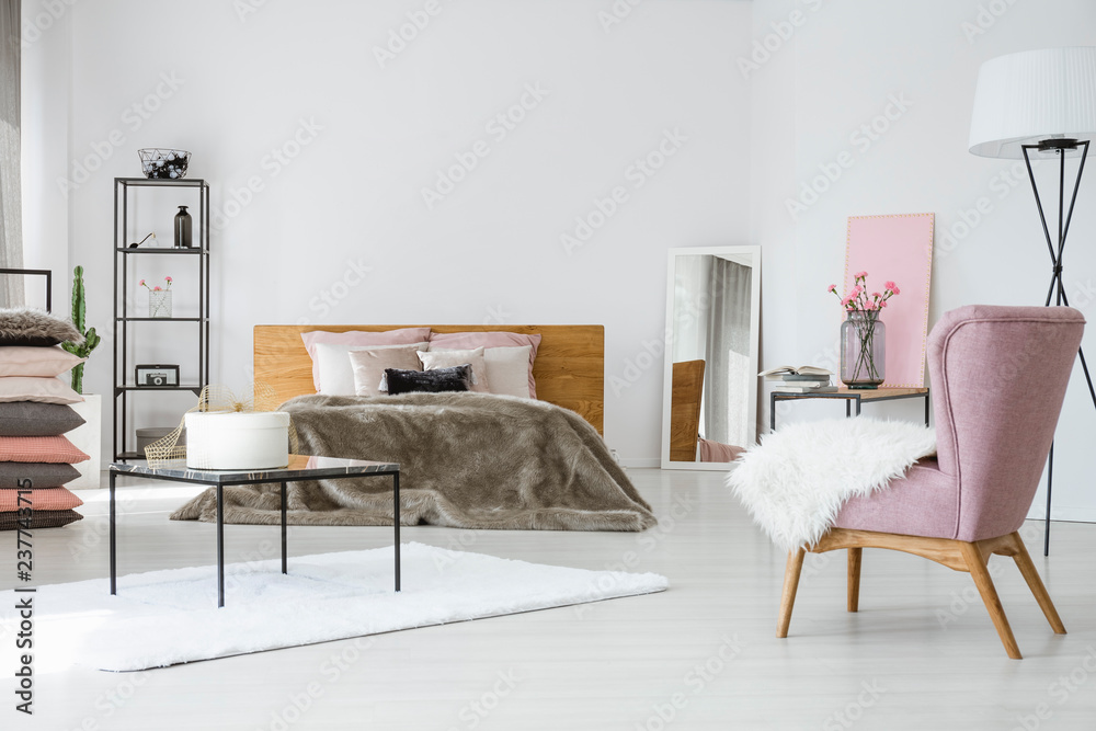Φωτογραφία Chic bright bedroom with king size bed, industrial furniture and trendy pink arm