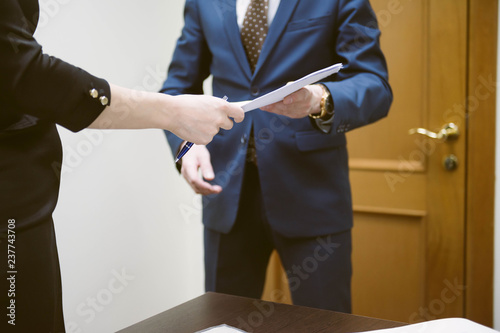 Conclude a contract. Business man and business woman sign a contract in the office. Businesswoman gives contract. 