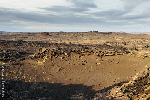 Volcanic landscape with empty lifeless land and cloudy sky on a sunny evening. Icelandic wilderness. No man's land. Reykjanes peninsula, southwest region of Iceland