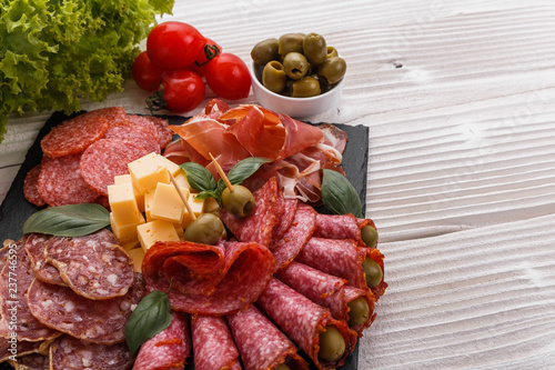 Cold smoked meat plate on a rustic wooden background