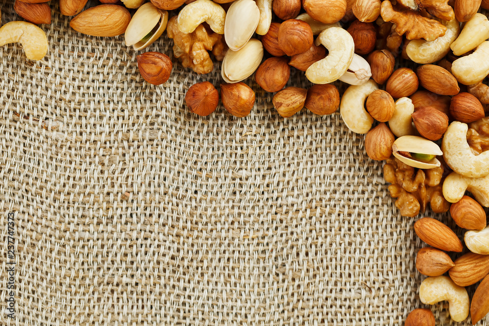 Mix of nuts lying on a background of brown cloth burlap. Mix of nuts lying on a background of brown cloth burlap.