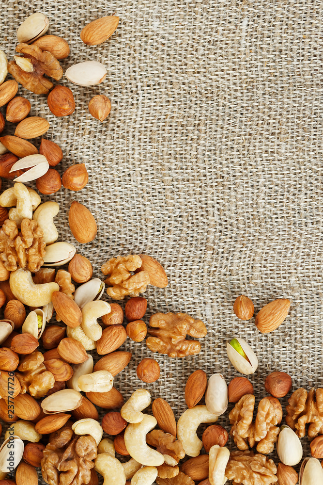 Mix of nuts lying on a background of brown cloth burlap. Mix of nuts lying on a background of brown cloth burlap.