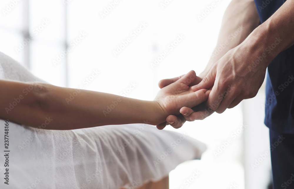 Fototapeta premium Massage of a young woman's hands, a masseur man.
