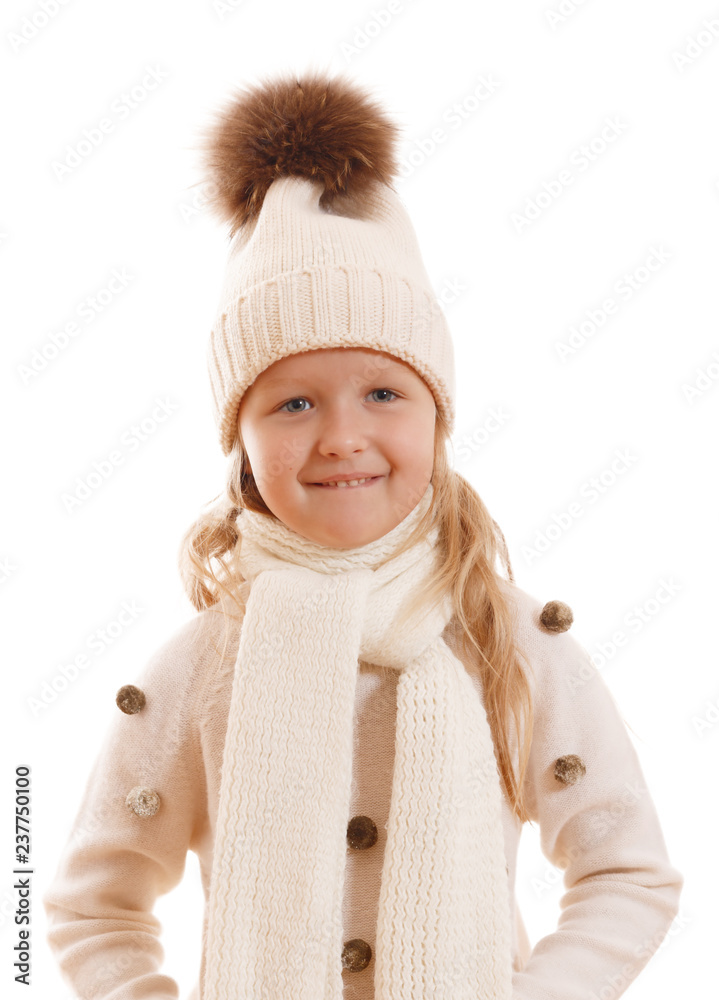 Little girl in a knitted hat with a big fur fluffy pompon, scarf and sweater.Isolated on white background