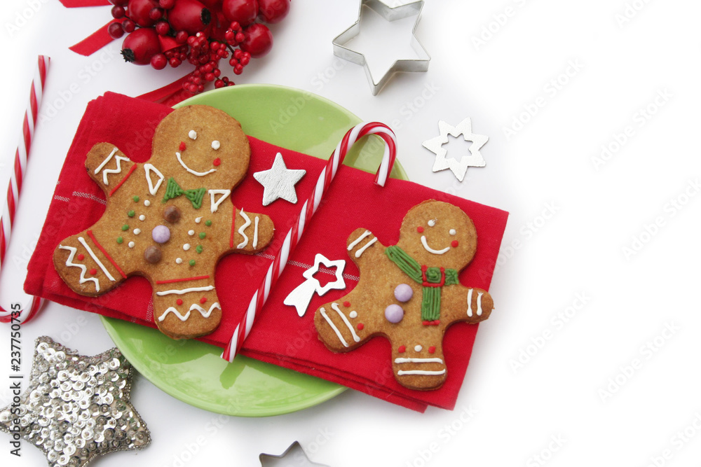 Gingerbread men on a red napkin with Christmas decorations isolated on white background
