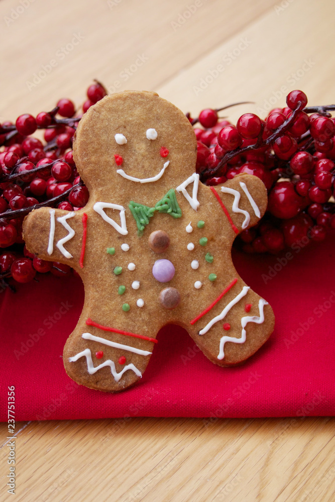 Christmas background  with gingerbread men with red berry decoration on wooden table