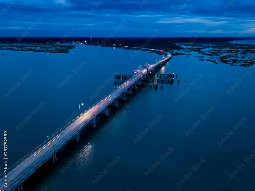 Aerial view of traffic moving across bridge at night with light trails. Aerial view of traffic moving across bridge at night with light trails.