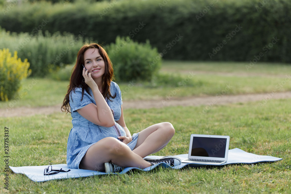 Young pregnant woman working in the park using her laptop Young pregnant woman working in the park using her laptop