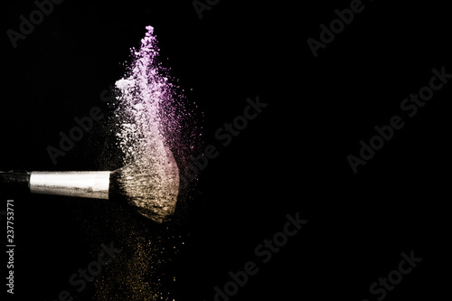 gold and purple powder splash and brush for makeup artist or beauty blogger in black background
