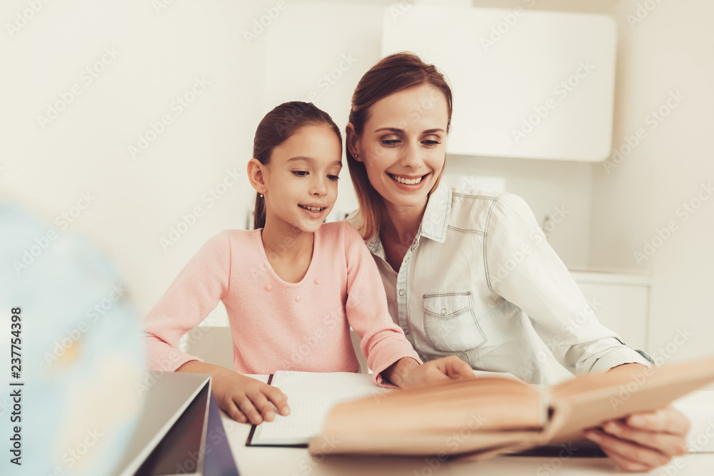 Mom Helps Daughter To Do Homework In The Kitchen. Mom Helps Daughter To Do Homework In The Kitchen.
