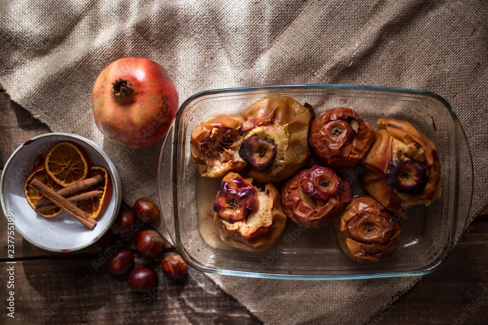 Roasted apples in a glass tray with chestnuts,, cinnamon, orange and pomegranate