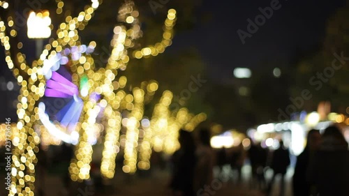 Bokeh view of people walking in a Christmas market at night