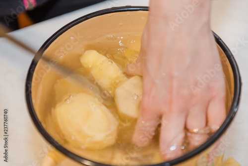 The girl cleans the potatoes. Cooking at home. Natural products. Cooking a dish of potatoes