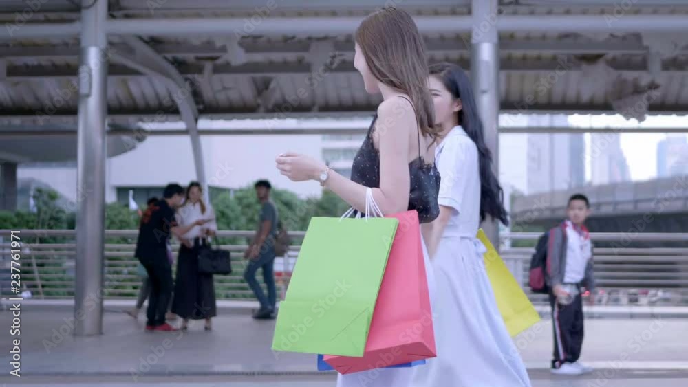 Beautiful woman with shopping bags smiling happily walking in city centre Thailand. shopping, happiness and fashion Concept. Slow Motion Beautiful woman with shopping bags smiling happily walking in city centre Thailand. shopping, happiness and fashion Concept. Slow Motion