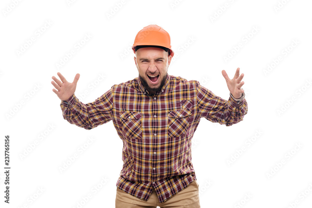 An angry and nervous worker in an orange helmet is talking loudly. Isolated white background An angry and nervous worker in an orange helmet is talking loudly. Isolated white background