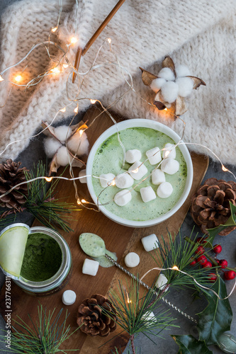 A cup of fragrant and tasty green matcha latte coffee decorated in a Christmas style.