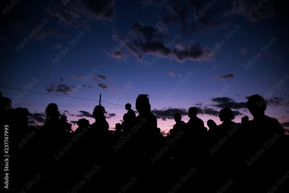 silhouettes of people on sunset background of sky