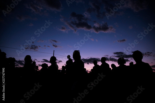 silhouettes of people on sunset background of sky