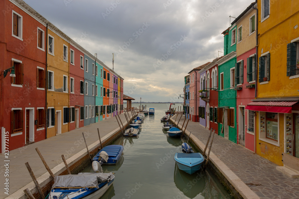 Burano Island - part of Venice, colored houses on the background of the channel.