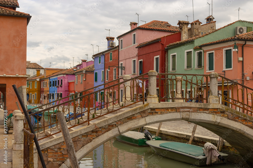 Burano Island - part of Venice, colored houses on the background of the channel.