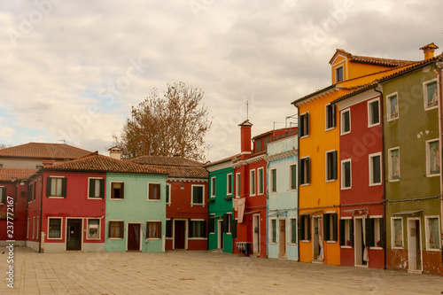 Burano Island - part of Venice, colored houses on the background of the channel. © Anna