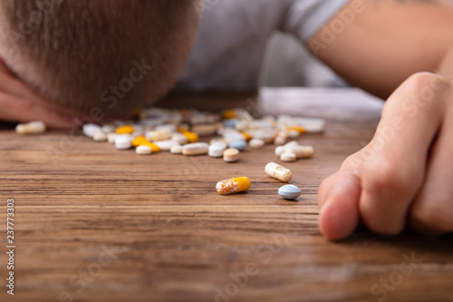 Sick Man With Many Pills On Desk