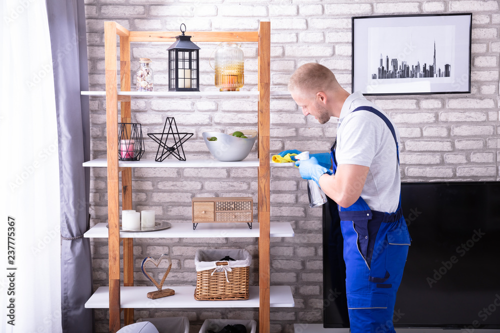 Young Male Janitor Cleaning Shelf Young Male Janitor Cleaning Shelf