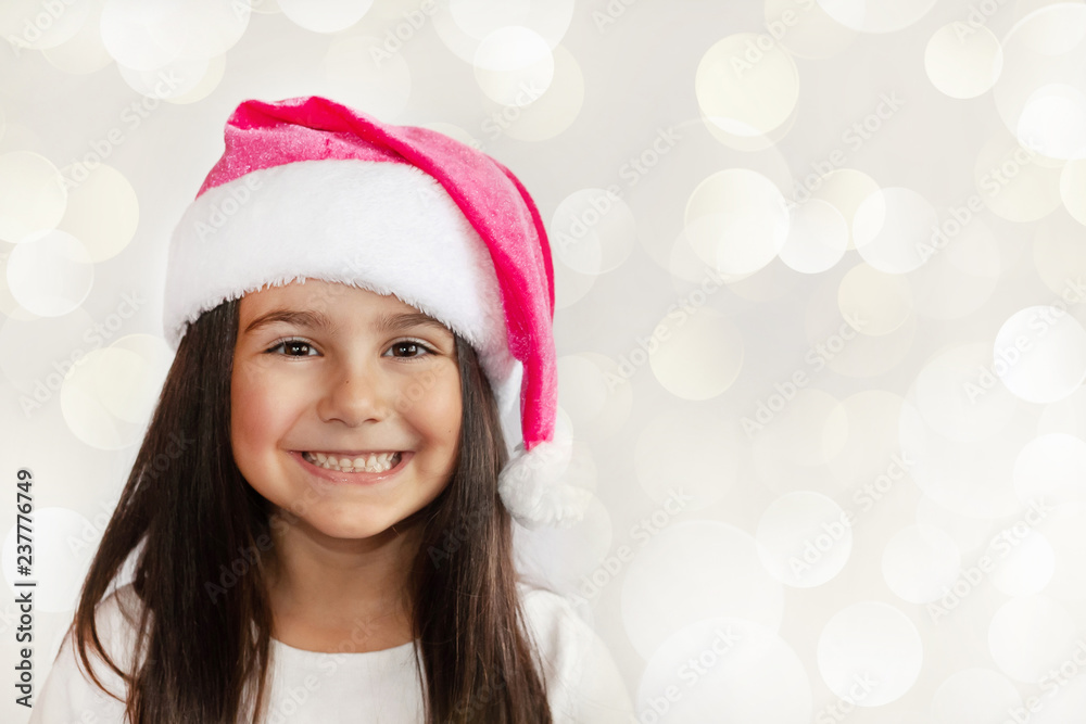 Happy cheerful child girl in Santa Claus Hat. Christmas time.