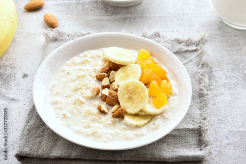 Oats porridge with banana slices, almond and dried apricot