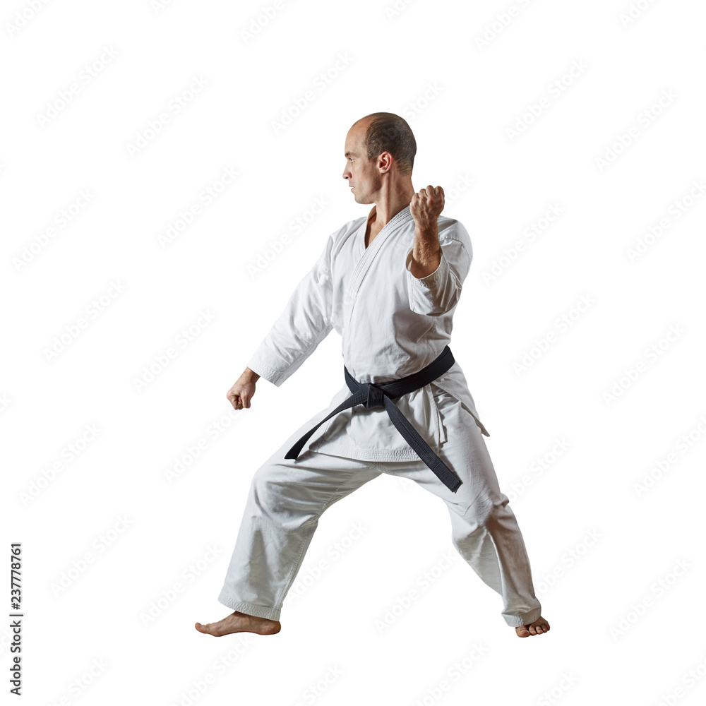 Black belt athlete doing formal karate exercises on a white isolated background Black belt athlete doing formal karate exercises on a white isolated background